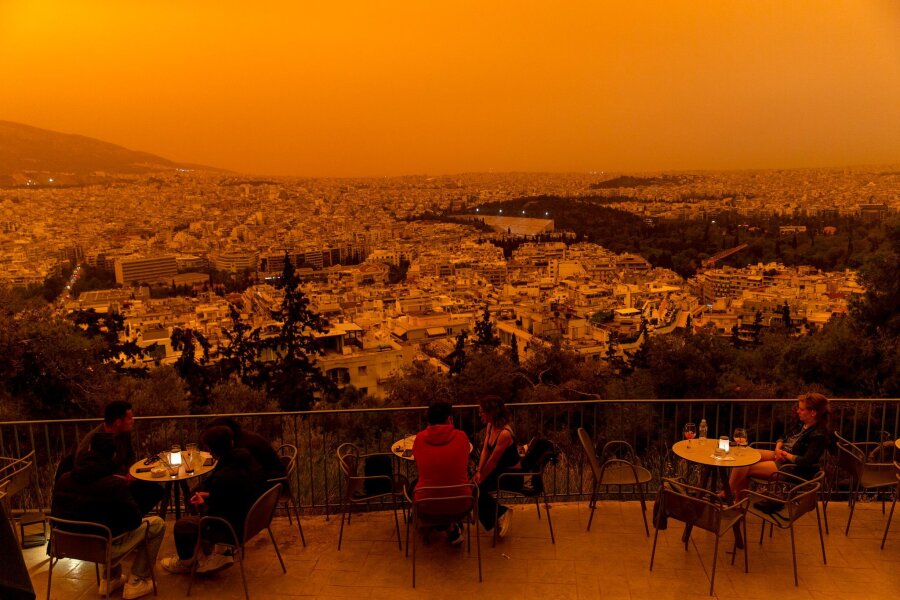 Bilder des Tages vom 24.04.2024 - Marsähnlicher Anblick: Staubwolken, die von Nordafrika über das Mittelmeer geweht wurden, hüllen die griechische Hauptstadt ein. Hier ein Blick von der Terrasse auf dem Filopappou-Hügel über Athen.