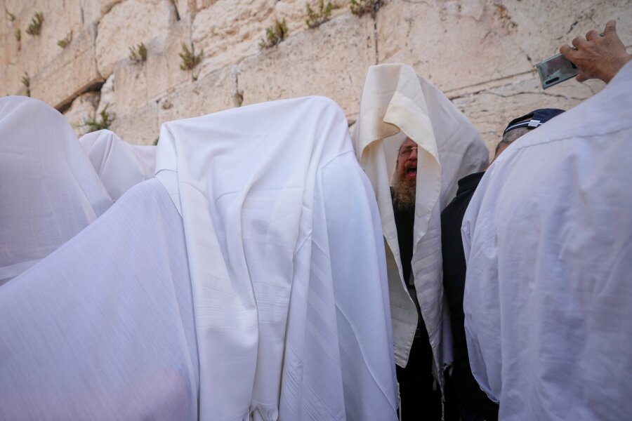 Bilder des Tages vom 25.04.2024 - In Gebetsschals gehüllte jüdische Männer der Priesterkaste der Kohanim nehmen während des Pessachfestes an der Westmauer in Jerusalem an einer Segnungszeremonie teil.