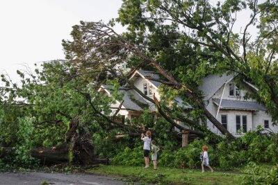 Bilder des Tages vom 27.05.2024 - Eine Familie sieht sich die Schäden am Haus ihres Nachbarn in Oklahoma an: Starke Stürme hinterließen in mehreren US-Bundesstaaten eine  Spur der Verwüstung.