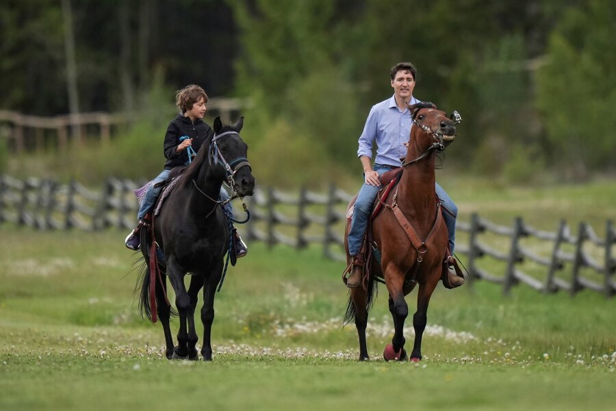 Bilder des Tages vom 27.06.2024 - Kanadas Premierminister Justin Trudeau und sein Sohn Hadrien reiten auf Pferden im kanadischen Nemaiah-Tal.