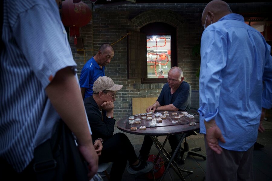 Bilder des Tages vom 27.06.2024 - Männer spielen Schach entlang der Hauptstraße von Wudaoying Hutong in Peking.