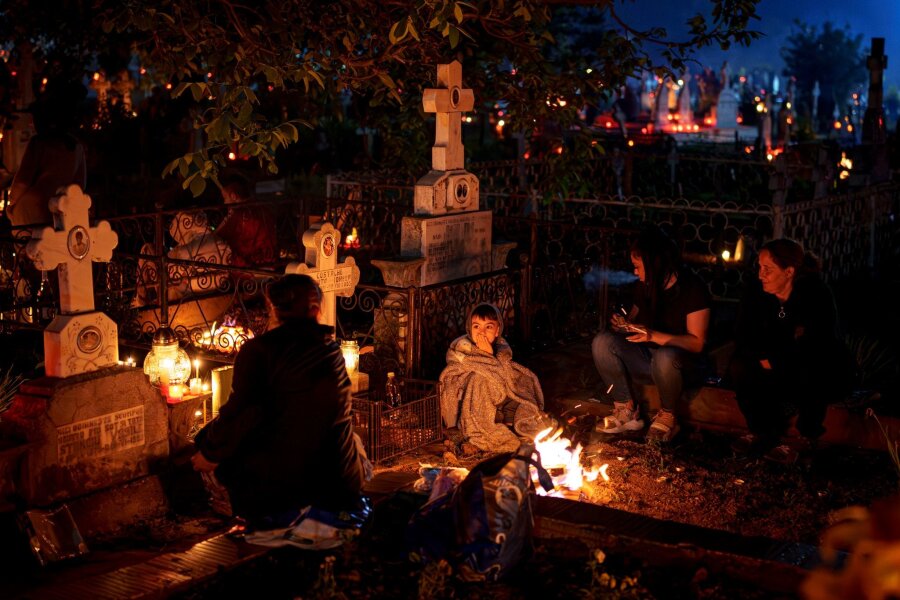 Bilder des Tages vom 28.04.2024 - Mit Feuern und Essen haben sich auf diesem Friedhof nahe Bukarest viele Gläubige versammelt, um ihren Angehörigen zu gedenken. Die Rumänisch-Orthodoxe Kirche hat nach der russischen zahlenmäßig die zweitgrößte orthodoxe Glaubensgemeinschaft der Welt.