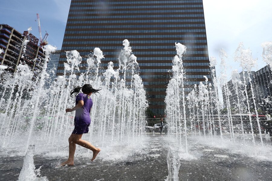 Bilder des Tages vom 28.04.2024 - Wasserspaß: Ein Kind spielt bei frühsommerlicher Hitze in einem Springbrunnen in Seoul.