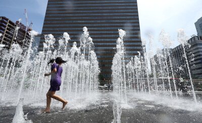 Bilder des Tages vom 28.04.2024 - Wasserspaß: Ein Kind spielt bei frühsommerlicher Hitze in einem Springbrunnen in Seoul.