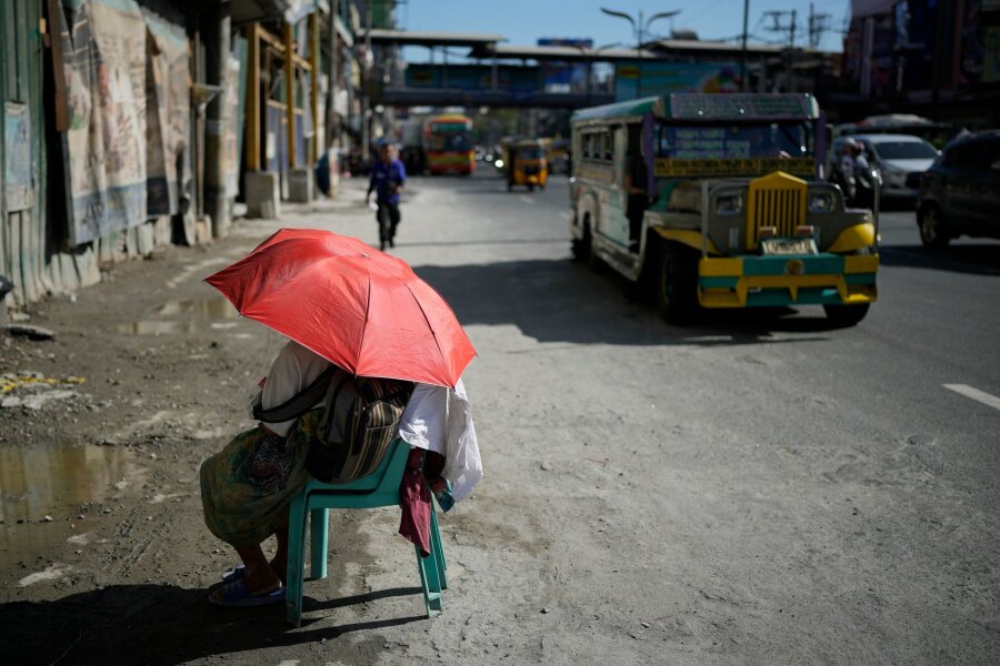 Bilder des Tages vom 29.04.2024 - Extreme Hitze in den Straßen von Manila: Eine Verkäuferin schützt sich mit einem Regenschirm vor der Sonne. Auf den Philippinen und in weiteren südostasiatischen Ländern herrschen Rekordtemperaturen von gefühlt über 50 Grad.