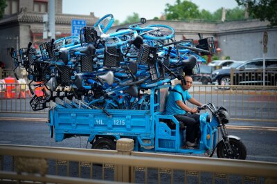 Bilder des Tages vom 29.06.2024 - Ein Arbeiter transportiert Fahrräder zu einem Touristenziel in der Innenstadt von Peking.