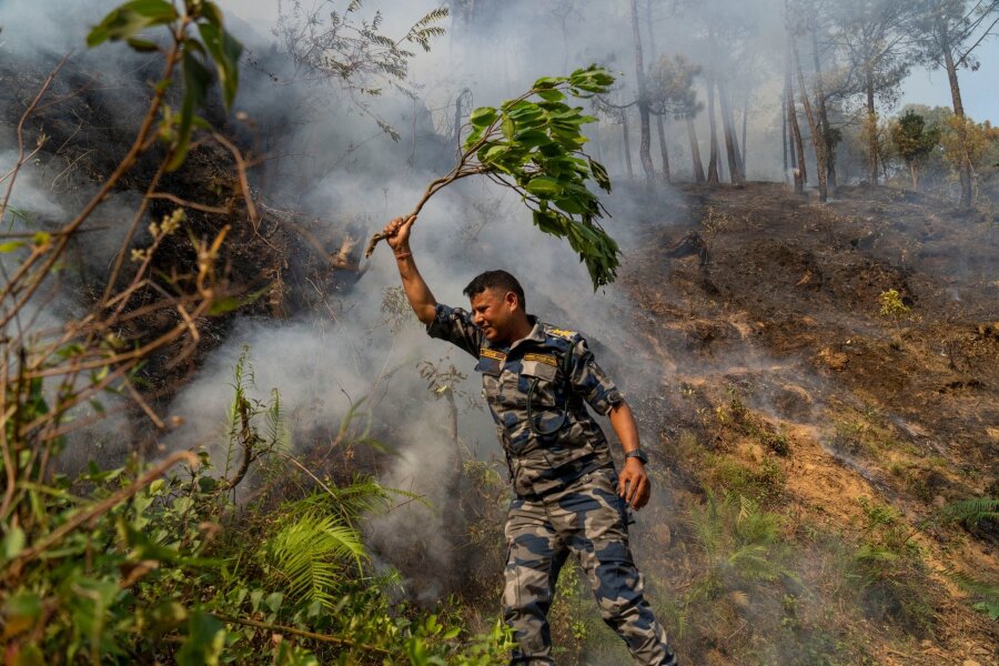 Bilder des Tages vom 30.04.2024 - In Nepal ist ein Waldbrand im Shivapuri-Nationalpark am Rande von Lalitpur ausgebrochen. Seitdem wird versucht, das Feuer zu löschen, wie durch diesen Polizisten.
