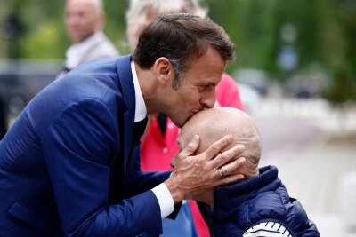 Bilder des Tages vom 30.06.2024 - Der französische Präsident Emmanuel Macron küsst den Kopf eines Mannes, als er vor einem Wahllokal zur Stimmabgabe ankommt.