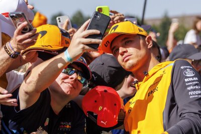 Bilder des Tages vom 30.06.2024 - Der Brite Lando Norris (r) vom Team McLaren macht vor dem Großen Preis von Österreich Fotos mit den Fans.