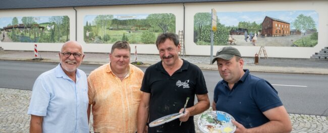 Bilder erinnern an Kleinbahn nach Sayda - Firmeninhaber Andreas Adam (von links) und Geschäftsführer Steffen Schuck von der Saydaer Straßen-, Tief- und Ingenieurbaufirma Adam freuen sich über die drei Wandbilder, die Andreas Schott und Eduard Reiswich an die Fassade des Betriebes gemalt haben. 
