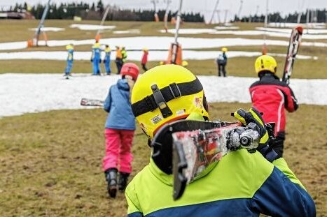 Bis zum letzten Fleckchen: Oberwiesenthaler bieten Skispaß - Wovon keiner begeistert ist: Die Lifte sind nicht in Betrieb. Das heißt, die Kinder müssen - so wie früher - ihre Ausrüstung zum Start tragen.