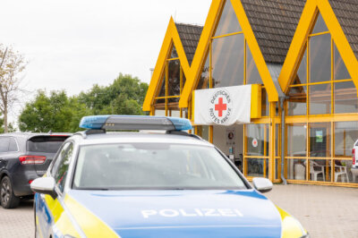 Bis zur Gewalt: Dutzende Straftaten an Impfstellen in Sachsen - Ein Polizeifahrzeug steht vor dem Impfzentrum des Vogtlandkreises, das Ziel eines Brandanschlages war.
