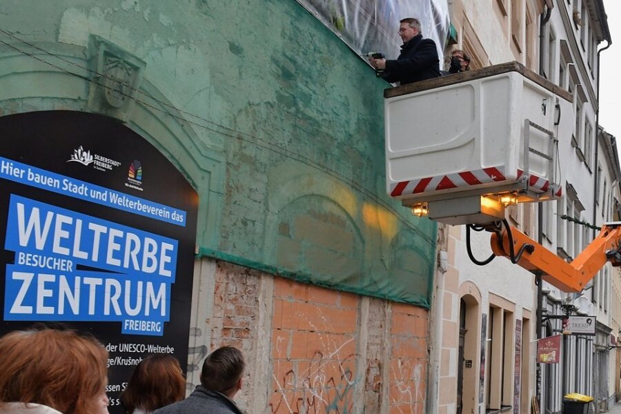 Ein Werbebanner kündet in der Petersstraße vom künftigen Welterbezentrum. Freibergs Oberbürgermeister Sven Krüger brachte am Dienstag symbolisch die letzte Schraube an. 