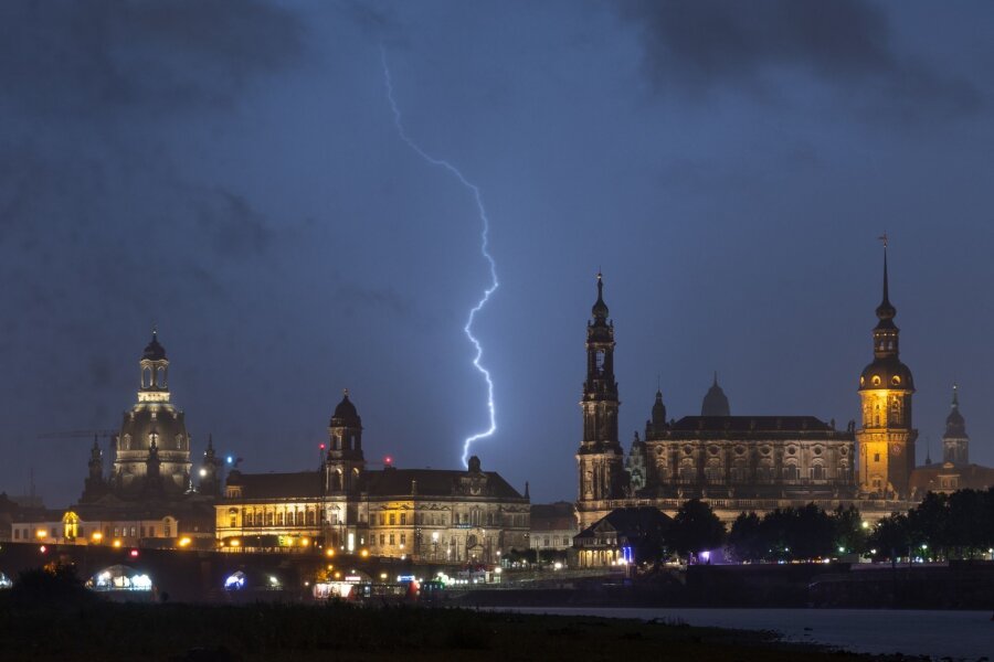 Blitzeinschlag in Dresdner Supermarkt: Zwei Verletzte - Ein Blitz ist während eines Gewitters am Himmel über der historischen Altstadtkulisse zu sehen.