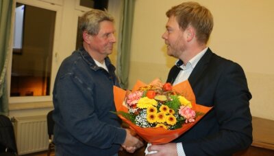 Blumen für ein Urgestein der Feuerwehr im Vogtland - Bürgermeister Michael Pohl gratuliert Wolfgang Rauh (links) zu der Auszeichnung mit der Verdienstmedaille des Landesfeuerwehrverbandes. 