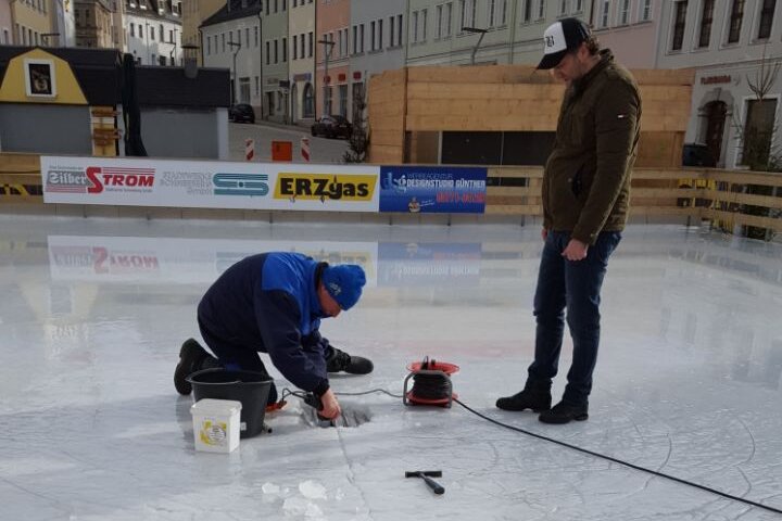 Böller-Attacke auf Eisbahn in Schneeberg: Bürgermeister stockt privat Belohnung für Hinweise auf - Mitarbeiter der Stadtwerke flicken das gut 30 Zentimeter große Loch in der Eisdecke.