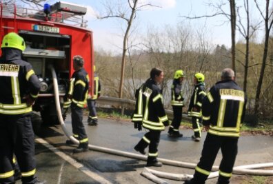 Brand auf Recyclinghof - Als die Löschwasserreserven nicht mehr reichten, verlegte die Reuther Feuerwehr mehrere hundert Meter Schläuche zu einem Teich. 