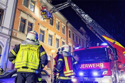 Brand in Auerbacher Mietshaus: Bewohner aus dem Fenster evakuiert - Mitglieder der Freiwilligen Feuerwehr Auerbach retten aus der zweiten Etage eine 65-jährige Bewohnerin mit der großen Drehleiter. Ein Stockwerk darunter holten sie einen 20-Jährigen aus der Wohnung. 