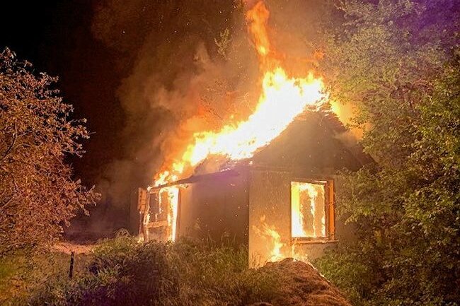 Brand in Reichenbach: Gartenhaus vollständig zerstört - In Reichenbach ist es am Mittwochabend zum Brand einer Gartenlaube gekommen. Die Feuerwehr konnte nur noch das Übergreifen auf Nachbargebäude verhindern.
