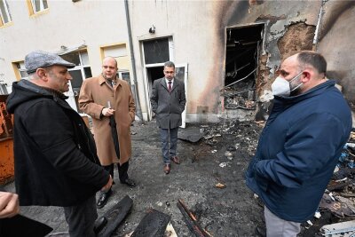 Brand vor Moschee in Chemnitz: Politisches Motiv laut Polizei "eher unwahrscheinlich" - Der türkische Generalkonsul Rifki Olgun Yücekök (2. von links) informierte sich am Montag vor Ort bei Mitgliedern der Gemeinde über die Brandschäden an der Moschee.