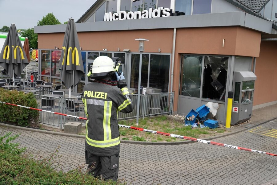 Brandanschlag auf McDonald’s in Zwickau: Polizei fasst Verdächtigen - Ein Polizist macht Fotos vom Tatort. Teile des Schnellrestaurants wurden durch eine Verpuffung schwer beschädigt.