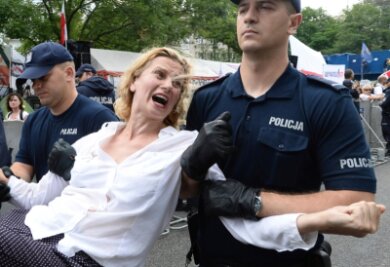 "Brüssel kann in Polen nichts ausrichten" - Polizisten tragen vor dem Parlamentsgebäude in Warschau eine Demonstrantin fort. Polens Regierung treibt ihre umstrittene Justizreform trotz Sanktionsdrohungen der EU-Kommission voran.