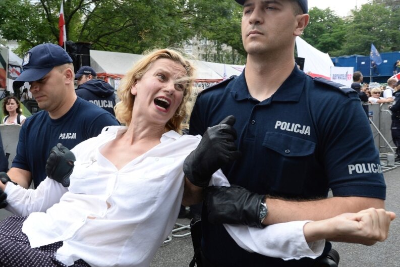 "Brüssel kann in Polen nichts ausrichten" - Polizisten tragen vor dem Parlamentsgebäude in Warschau eine Demonstrantin fort. Polens Regierung treibt ihre umstrittene Justizreform trotz Sanktionsdrohungen der EU-Kommission voran.