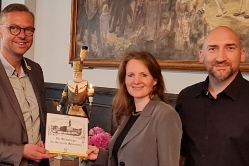 Ein Exemplar des Ehrenbürgerbuchs für Schneeberg erhielt Bürgermeister Ingo Seifert (l.) von den Autoren Ina Georgi und Stefan Espig.