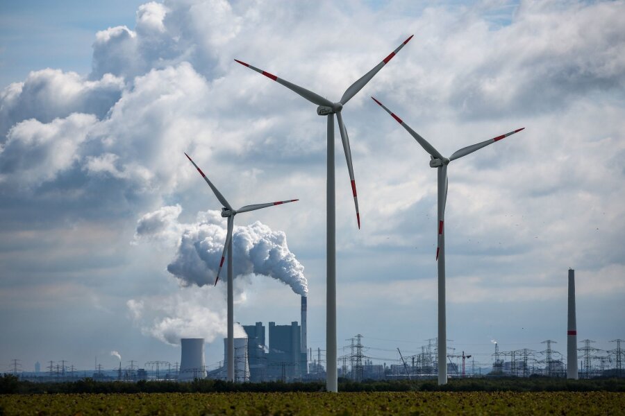 Bund will Kohleregionen gezielter unterstützen - Windräder drehen sich vor der Kulisse des Braunkohlekraftwerks Schkopau westlich von Halle (Saale).