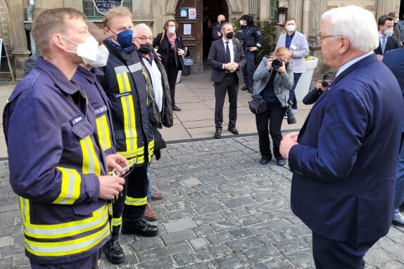 Bundespräsident Frank-Walter Steinmeier (rechts) spricht mit den Feuerwehrleuten aus Glauchau-Niederlungwitz. 
