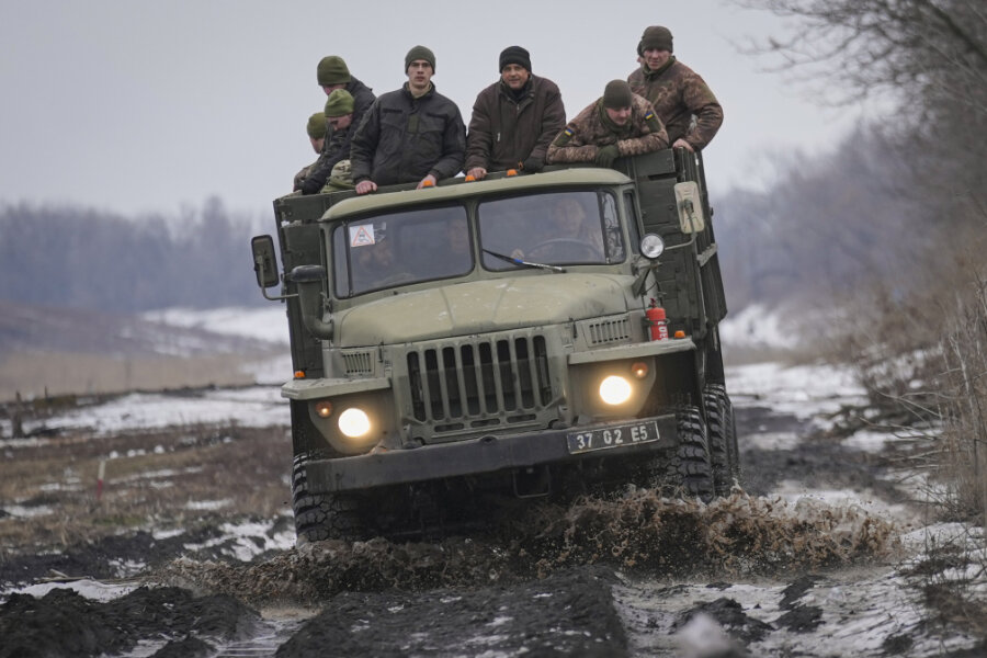 Bundesregierung: Deutsche sollen Ukraine verlassen - Ukrainische Soldaten stehen auf der Ladefläche eines LKWs, der auf einer schlammigen Straße fährt. Der Aufmarsch russischer Truppen an der ukrainischen Grenze sorgt im Westen seit Wochen für Ängste vor einem möglichen Angriff Moskaus auf die Ukraine, was der Kreml dementiert. 