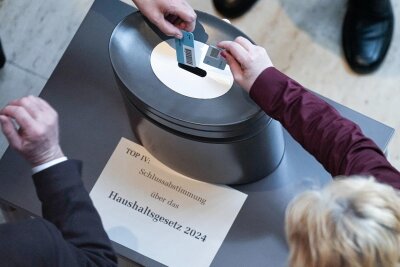 Bundestag beschließt Etat 2024 – mit Verspätung - Namentliche Abstimmung zum Haushalt im Bundestag: Abgeordnete werfen ihre Stimmkarten in die Abstimmungsbox.