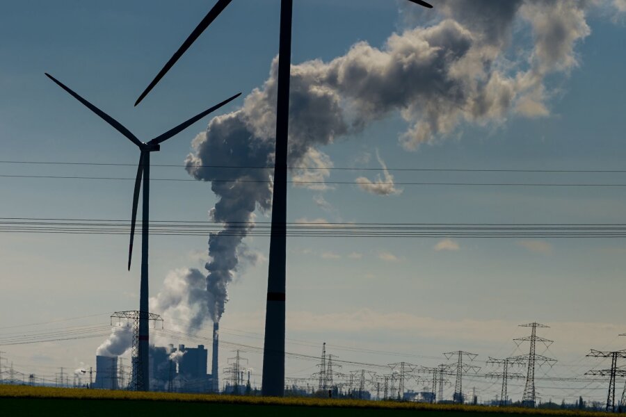Bundestag beschließt Reform des Klimaschutzgesetzes - Windräder im Energiepark Bad Lauchstädt, eine Stromtrasse und qualmende Schornsteine in einem Industriegebiet.