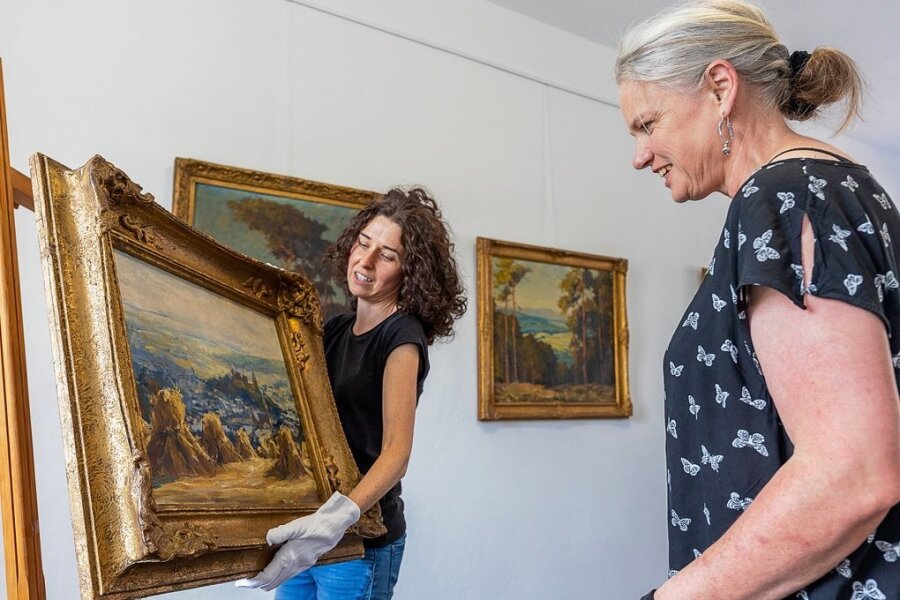 Burgmuseum empfängt Besucher jetzt mit einem neuen Bild - Museumsmitarbeiterin Nadine Holesch (links), und Museumsleiterin Sina Lorbeer-Klausnitz richten das Bild von Otto Eduard Pippel aus, dessen Kauf durch Spenden finanziert wurde. 
