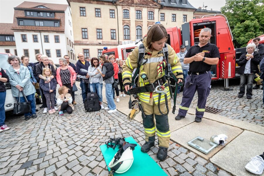 Burgstädter Blaulichtmeile: Was wiegt eine Feuerwehrfrau? - Feuerwehrfrau Aileen Radzanowski legt ihre Ausrüstung an, mit der sie insgesamt mehr als 100 Kilogramm wiegt.