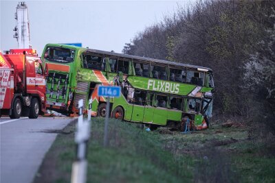 Bus-Unglück auf A9 bei Leipzig: Drei Tote identifiziert - Staatsanwaltschaft ermittelt jetzt gegen den Fahrer - Mit einem Kran ist der verunglückte Bus am Mittwochabend aufgerichtet worden.