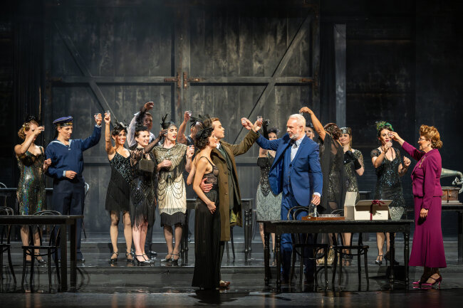 Zum Happy End wird es nicht kommen: Herr Schultz (Matthias Winter) und Fräulein Schneider (Sylvia Schramm-Heilfort, beide rechts am Tisch) feiern mit Sally Bowles (Sybille Lambrich) und Clifford Bradshaw (Jannik Harneit) ihre Verlobung. 