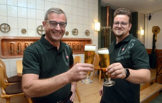 Carlsberg eröffnet Bierbotschaft im Brauereigutshof Wernesgrün - Gunnar und Alexander Ott (von links), die Betreiber der Wernesgrüner Brauschenke auf dem Gutshof, stoßen auf die Wiedereröffnung an.