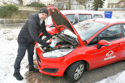 Carsharing: Warum sich Freiberg zum Erfolgsmodell mausert - Thomas Oppermann aus Freiberg ist Fahrzeugwart an einem Ford Fiesta, füllt hier Frostschutz in die Scheibenwaschanlage nach. 
