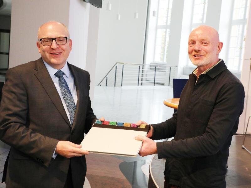 Chemnitz 2025: Geschäftsführer der Kulturhauptstadt GmbH steht fest -             Oberbürgermeister Sven Schulze (l, SPD) überreicht Stefan Schmidtke ein Begrüssungsbuch.