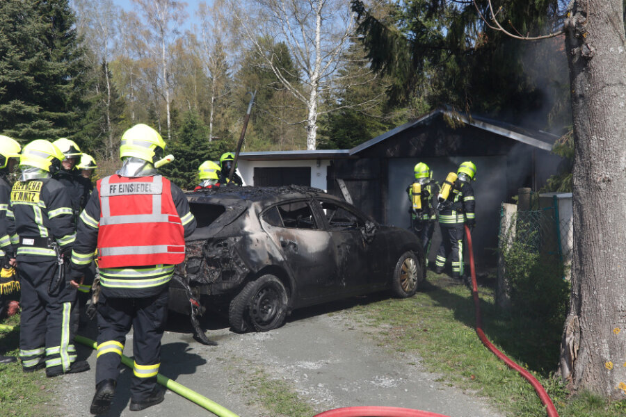 Chemnitz: Auto brennt in Garage aus - Nach dem Löscheinsatz zog die Feuerwehr den Mazda aus der Garage.