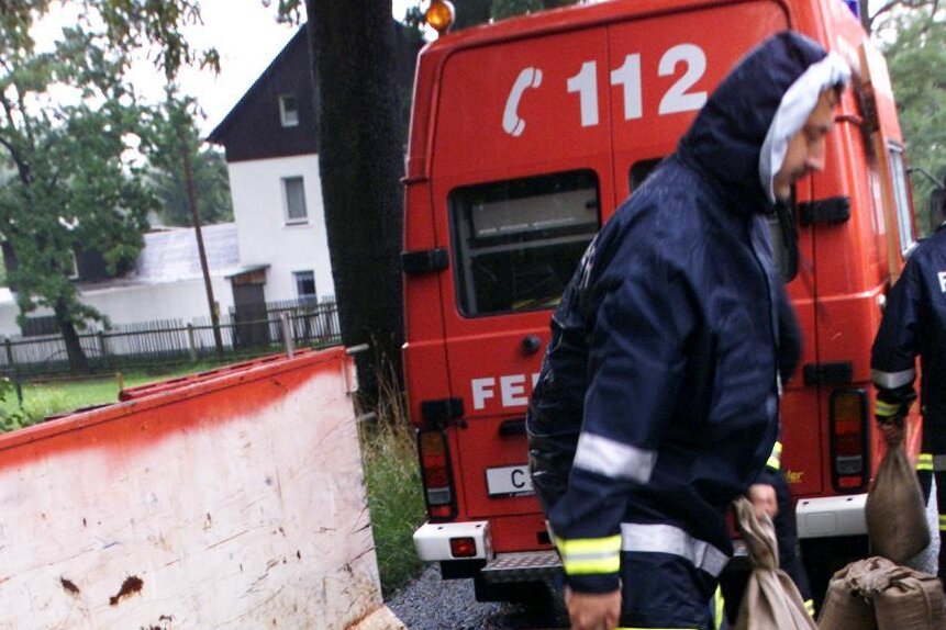 Chemnitz: Größte Hochwasserwelle seit 1954 - Mit Sandsäcken versuchen die Feuerwehrleute, den Pleißenbach einzudämmen.