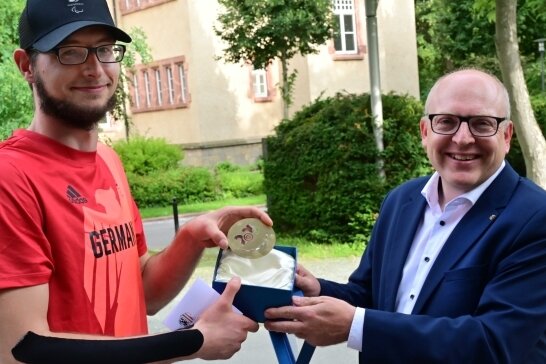 Chemnitz verabschiedet Oliver Hörauf zu Paralympics in Tokio - Eine Medaille mit Kulturhauptstadt-Logo als Glücksbringer: Oliver Hörauf (links) wird von OB Sven Schulze verabschiedet. 