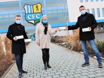 Chemnitzer FC sorgt für Maskenspende - Ralf Hunger, Fachberater von Dr. Butze in Klingenberg (r.), übergibt an CFC- Vorstandschefin Romy Polster und Marketingchef Tommy Klotke  (l.) 2000 medizinische Masken.