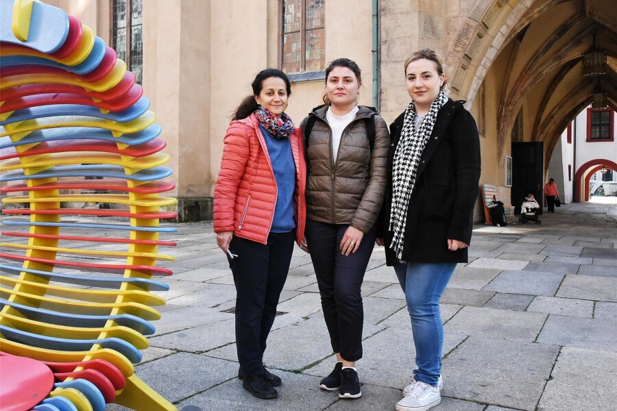 Chemnitzer Gemeinschaft der Armenier ruft zu Hilfe für Geflüchtete auf - Kristina Gräf, Sona Grigoryan und Anzhela Grigoryan (von links) vor der Jakobikirche. Die Stadtmöblierung hat zufällig die Farben der armenischen Flagge.