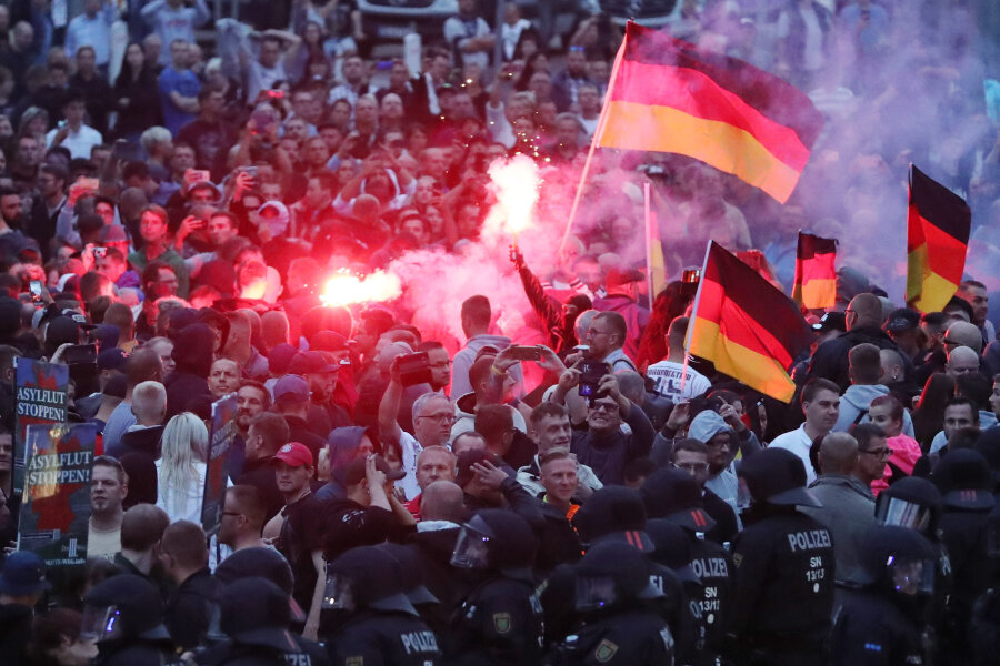 Demonstranten der rechten Szene zündeten am Montag in der Chemnitzer Innenstadt Pyrotechnik und schwenkten Deutschlandfahnen. 
