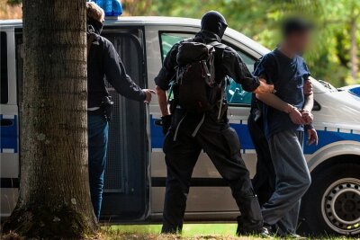 Chemnitzer Rechtsterroristen planten Umsturz in Deutschland - Am Montag vor dem Bundesgerichtshof in Karlsruhe: Einer der mutmaßlichen Rechtsterroristen aus der Chemnitzer Szene, die am Morgen in Bayern und Sachsen festgenommen wurden, wird von Polizisten abgeführt. 