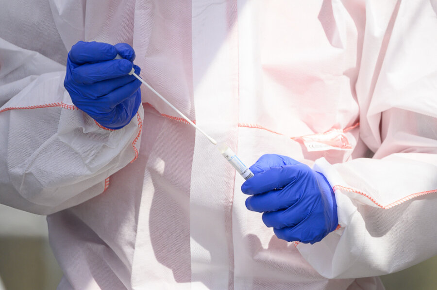 Corona: Die Lage im Vogtland am Donnerstag, 16. April - Ein Mitarbeiter hält in einem Corona-Abstrichzentrum einen Test auf das Coronavirus Sars-Cov-2 in den Händen.