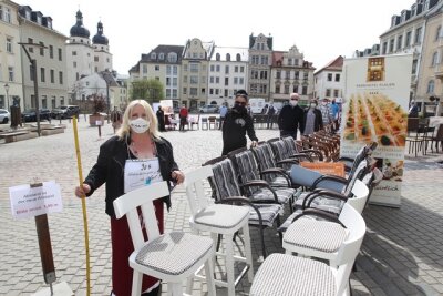 Mit dem Zollstock achteten die vogtländischen Kneipiers bei ihrem Protest auf dem Plauener Altmarkt auf die Einhaltung des Mindestabstandes. Sinnbild ihrer Protestaktion am Freitag waren die leeren Stühle.