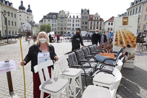 Mit dem Zollstock achteten die vogtländischen Kneipiers bei ihrem Protest auf dem Plauener Altmarkt auf die Einhaltung des Mindestabstandes. Sinnbild ihrer Protestaktion am Freitag waren die leeren Stühle.